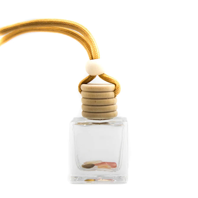 A charming car diffuser to freshen your travels. Embellished with courage, creativity, and vitality inducing carnelian gemstone crystals.  Fragranced car diffuser oil housed in a clear glass rectangular bottle with a wooden top, and cord.